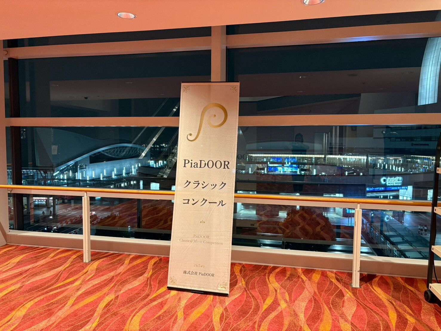 夜の窓辺に立つPiaDOORクラシックコンクールのバナー