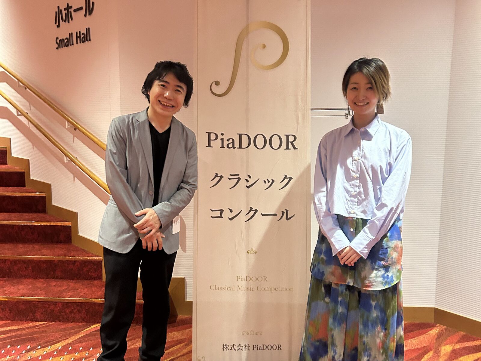 PiaDOORクラシックコンクールのバナーの横に立つ審査員の先生方